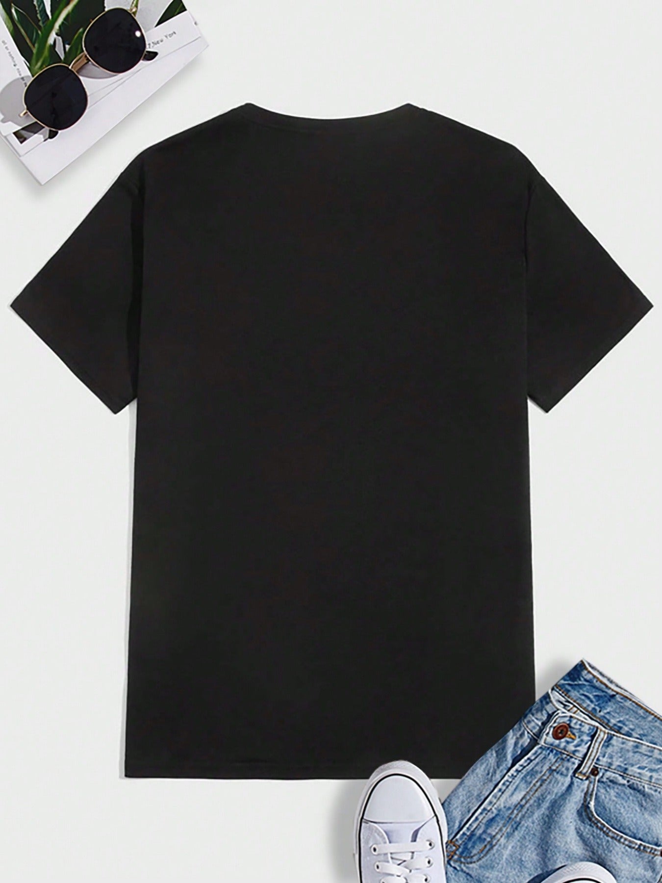 Black t-shirt on a white background with sunglasses and jeans partially visible.