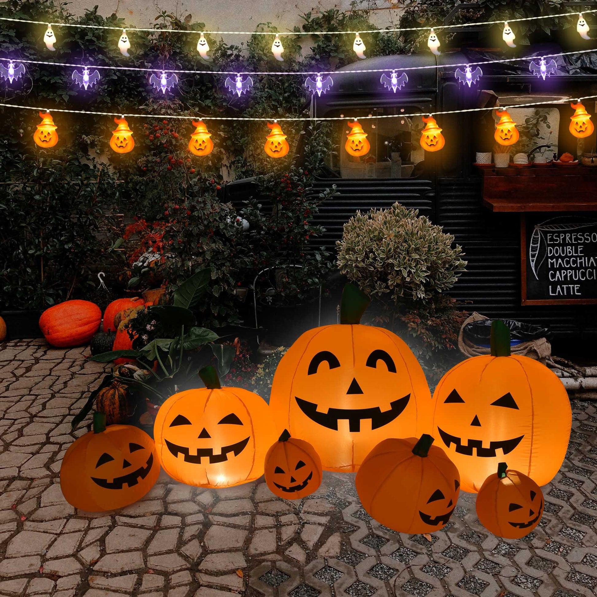 Halloween decorations with illuminated pumpkins and string lights on a patio.