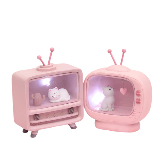 Two small pink vintage-style televisions with cat figurines on a pink and white marbled background.