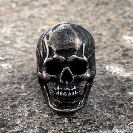 Skull-shaped metal object on a textured surface